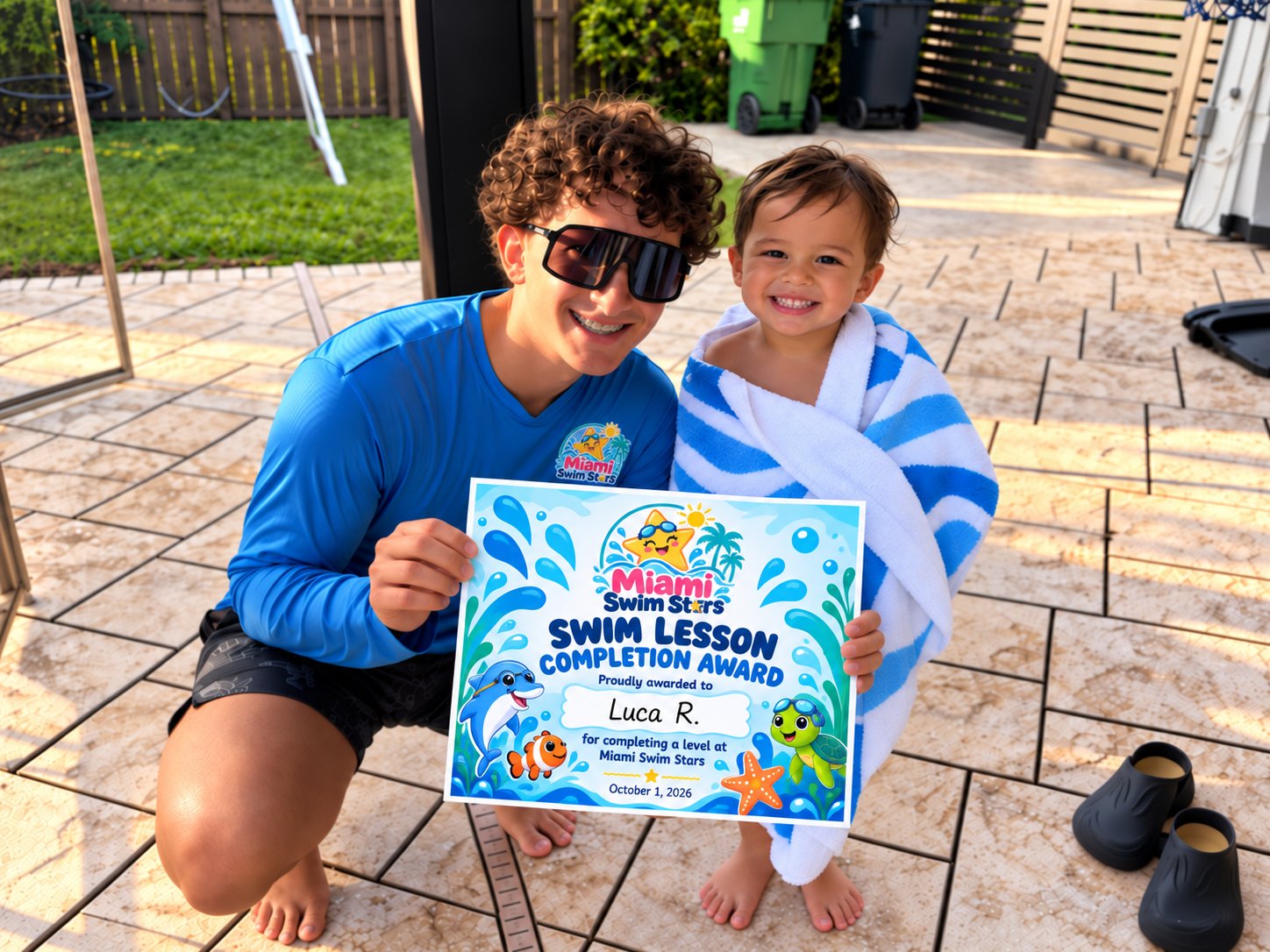 Coach Zavier Figueredo with a smiling young swimmer holding a Miami Swim Stars completion award